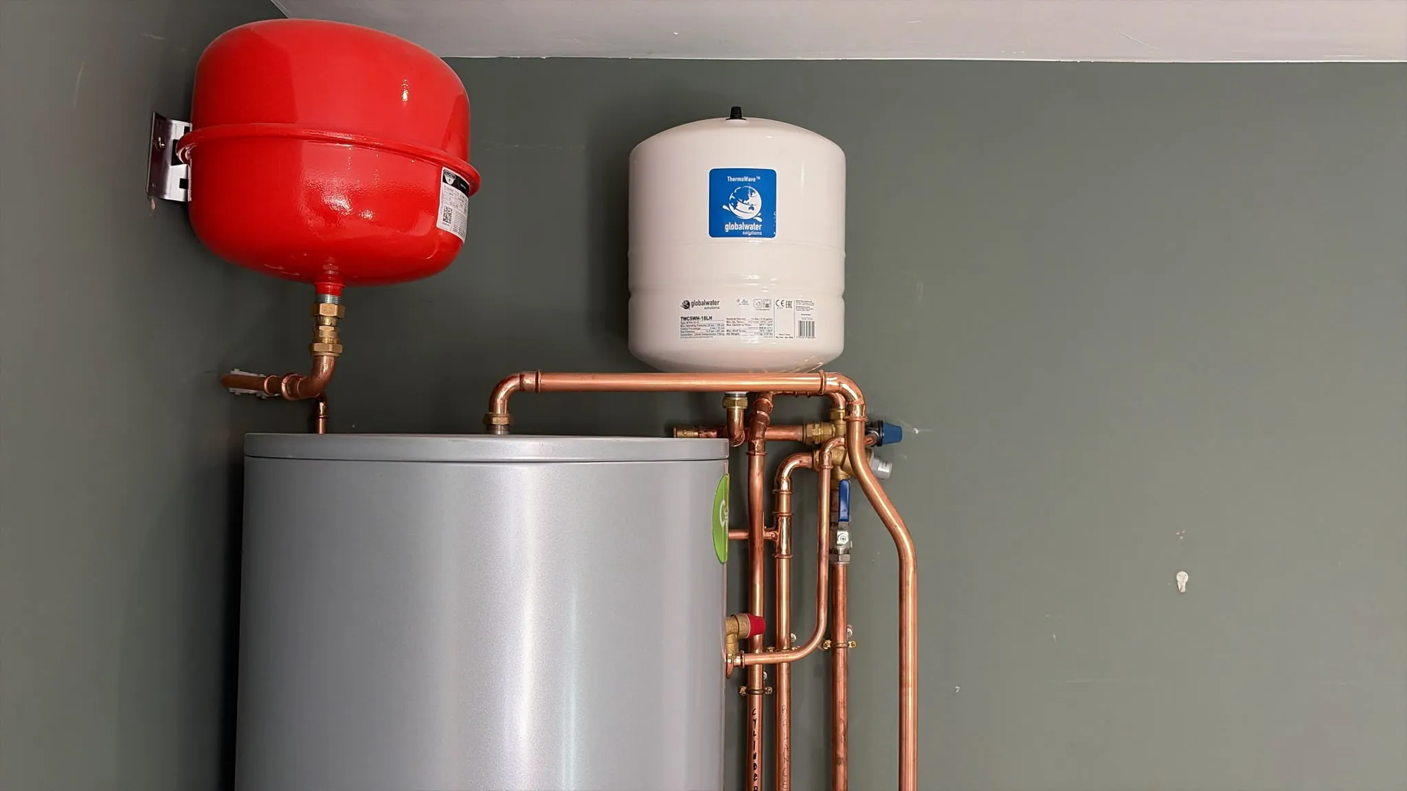 A Joule Cyclone Platinum 250 litre unvented hot water cylinder with a red heating expansion vessel and a white potable expansion vessel above it, in Rickmansworth